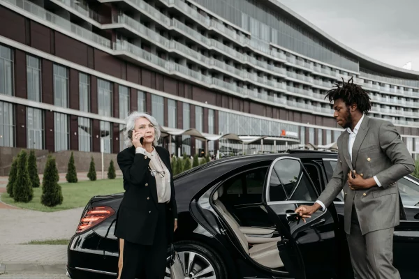 Limousine chauffeur opening door for guest