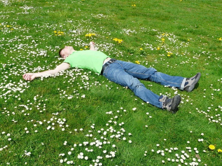 Man lying in a green grassy field