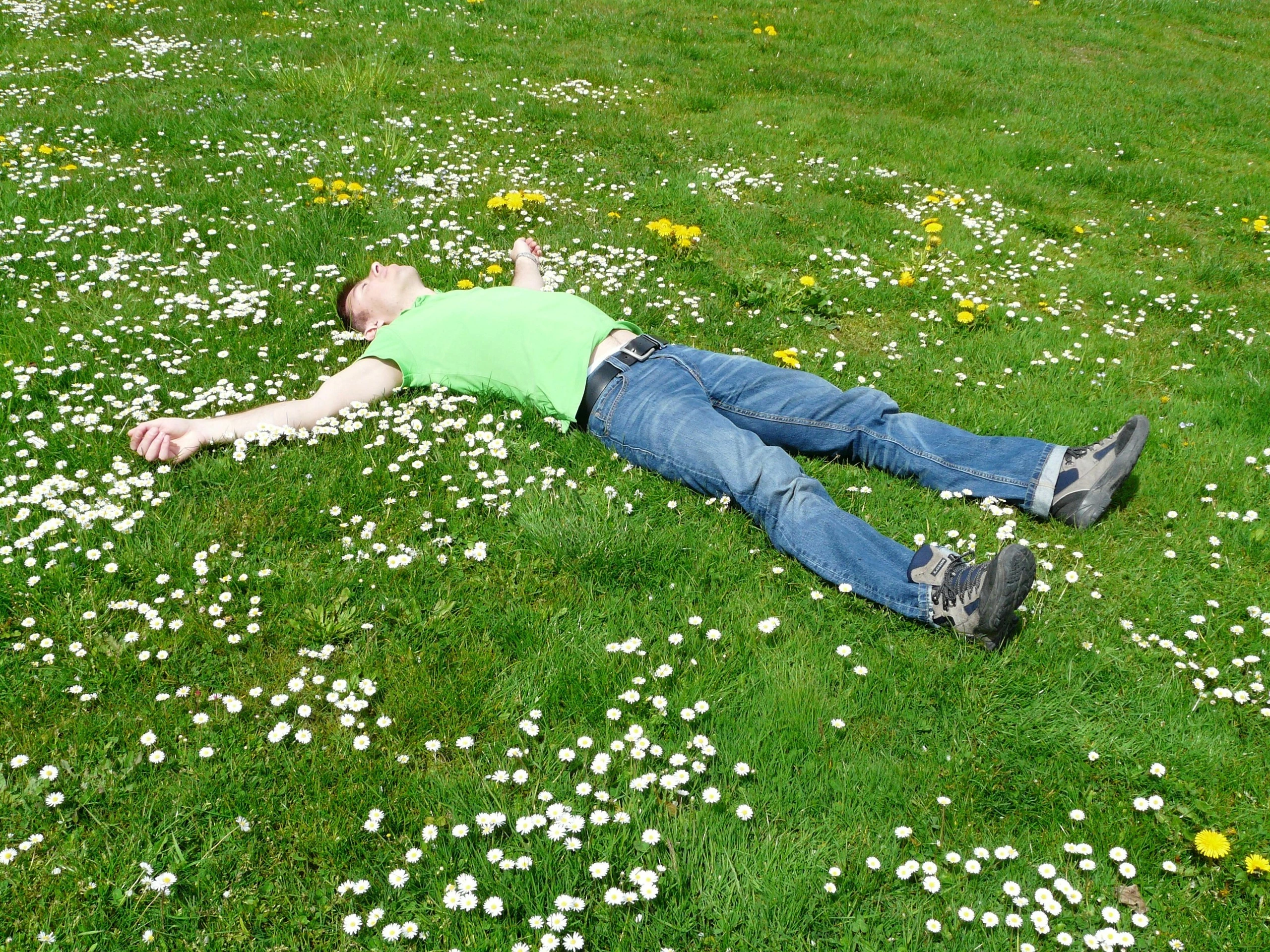 Man lying in a green grassy field