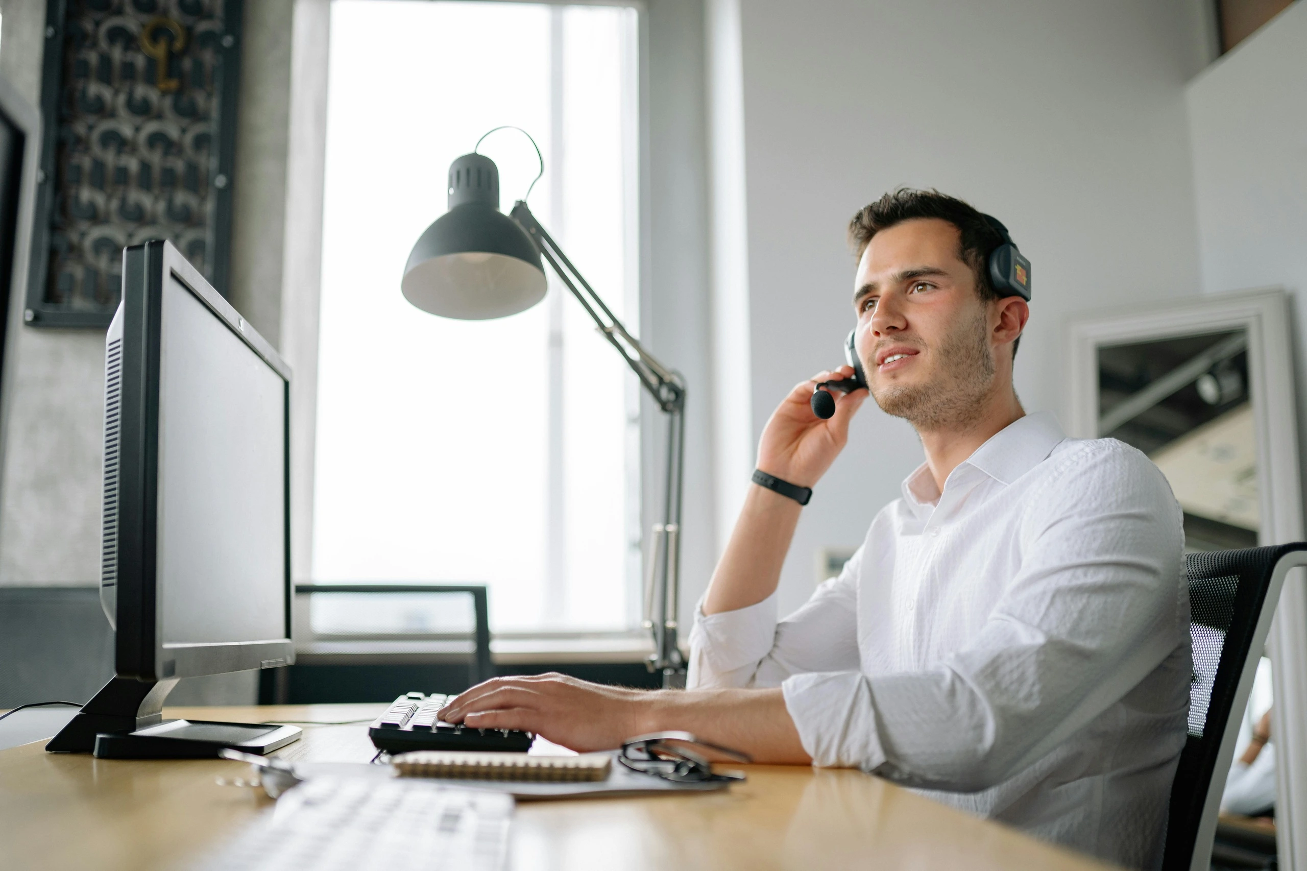 Man with headset sitting at a desk