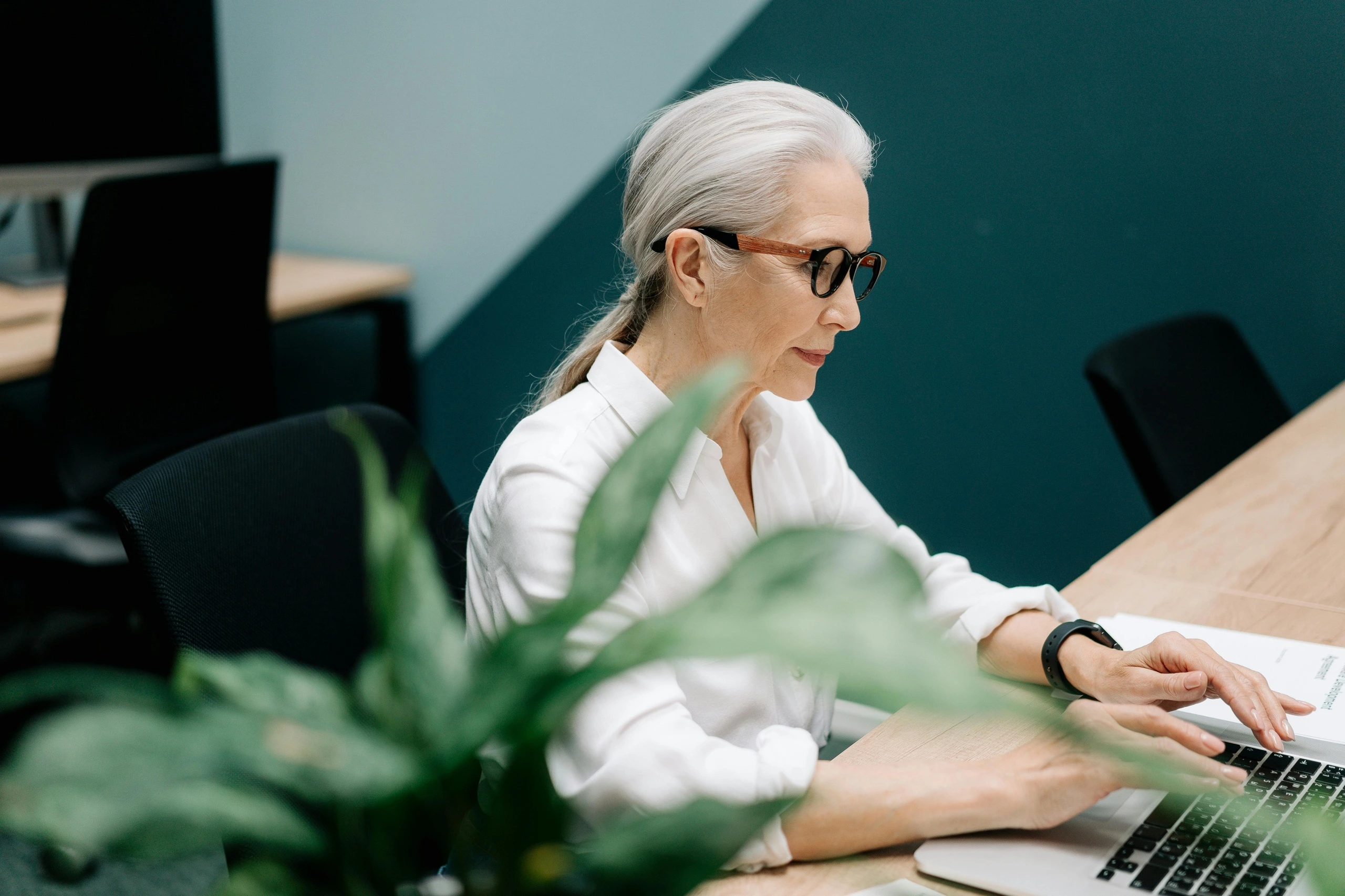 Mature woman sitting at a desk using a computer