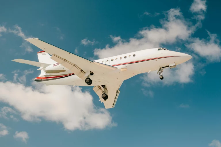 Private jet in flight with blue sky and clouds