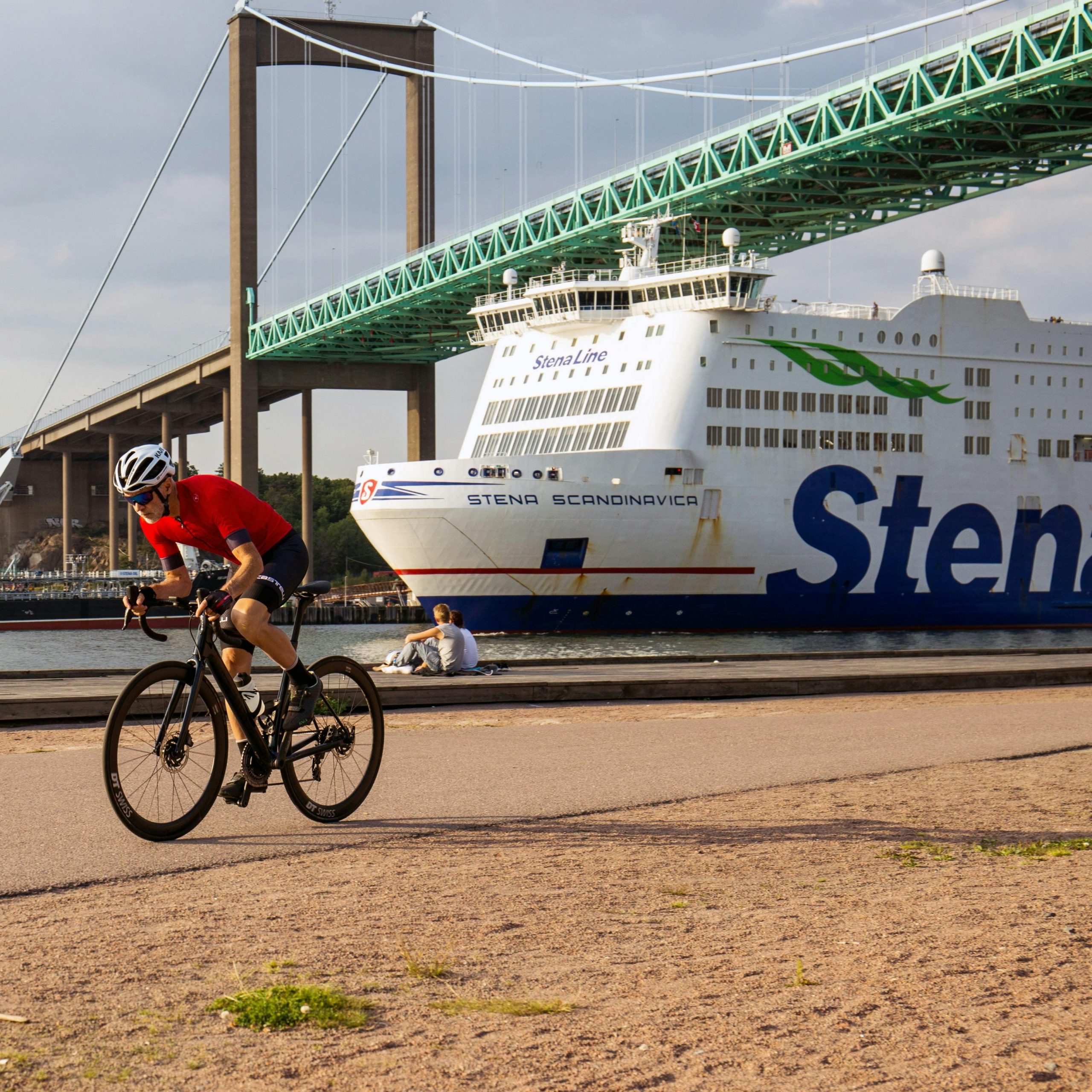 Stena Line Ferry passing under a bridge with a bicyclist in foreground