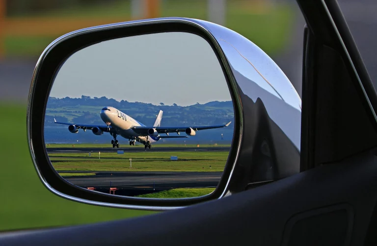 Airplane departing in rearview mirror